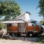 Volkswagen camper met luifel op een camping in Normandië