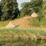 Twee Bell tenten op een heuvel naast een sloot in Gelderland