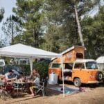 Volkswagen camper met een partytent ernaast op een camping in Frankrijk