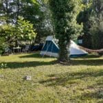 Wit met blauwe tent op een groen kampeerveld in Frankrijk