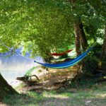 Hangmatten aan de rivier bij Camping la Berge Ombragée in de Dordogne