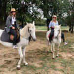Twee paarden met ruiters op een camping in Frankrijk