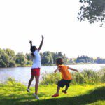 Twee kinderen springen naast het meer Vidlák