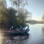 Twee volwassenen roeien in een boot op water in Zuid-Holland