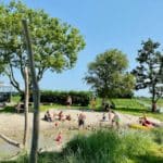 Spelende gezinnen op een strandje in West-Friesland
