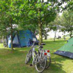 Twee tenten en twee fietsen op een groen kampeerveld in Midden-Limburg