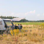 Tent met fietsen ernaast uitkijken over het platteland van Overijssel