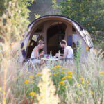 Man en vrouw voor een tent op een camping in het oosten van Nederland