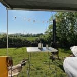 Stoelen onder de luifel van een T3 camper op een camping in Gelderland