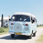 Blauwe volkswagen camper rijdend in Noord-Holland