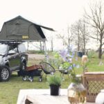 Auto met daktent op een kampeerveld tussen de Friese meren