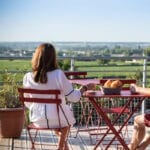 Vrouw ontbijt op een terras met uitzicht op het landschap van de Bourgogne