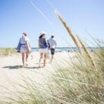 Drie mensen lopen naar het strand van de Atlantische oceaan in Frankrijk