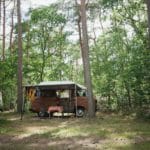 Camperbus met luifel in het bos