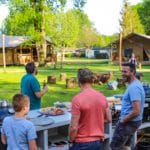 Gezin aan het barbecuen voor twee safaritenten in Brabant