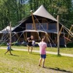 Drie kinderen aan het spelen voor een Koningslodge in Noord-Brabant