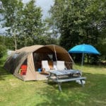 Beige tent op een groen kampeerveld Camping Les Arbois in Frankrijk