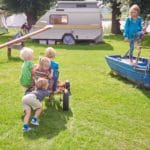 Vijf kinderen spelen op een groene camping bij Arnhem
