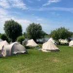 Zes beige tenten op een camping aan de oever van de Rijn