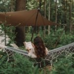 Vrouw leest een boek in een hangmat in het bos van Utrecht