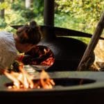 Vrouw stookt vuur op een houtoven in Utrecht
