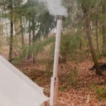 Schoorsteen van een ingerichte tent in het bos