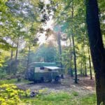 Camperbus met luifel in het bos in Drenthe