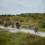 Vier mensen aan het fietsen in de duinen van Ameland