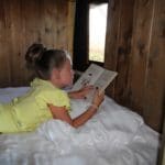 Kind leest op bed in een safaritent