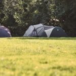 Grijze tent op groen kampeerveld in het westen van Nederland