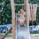 Meisje glijdt van een glijbaan op kindvriendelijke Camping Zwinderen