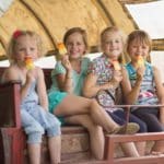 Vier meisjes met een ijsje in een huifkar