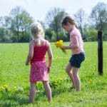 Twee kinderen op het weiland van een kindvriendelijke boerderijcamping