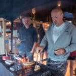 Twee mannen aan het barbecuen op adults only camping Qui Vivra Verra in Frankrijk