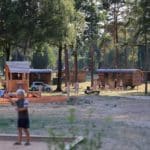 Speeltuin met daarachter een pipowagen op Camping Huttopia de Meinweg