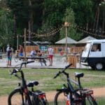 Twee fietsen met een verlicht terras op Camping Huttopia de Meinweg