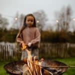 Meisje bakt marshmallows boven een vuur