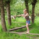 Meisje klimt over het blotenvoetenpad op een camping in Gelderland