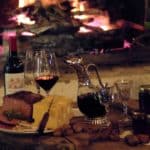 Tafel met eten en wijn voor een vuur